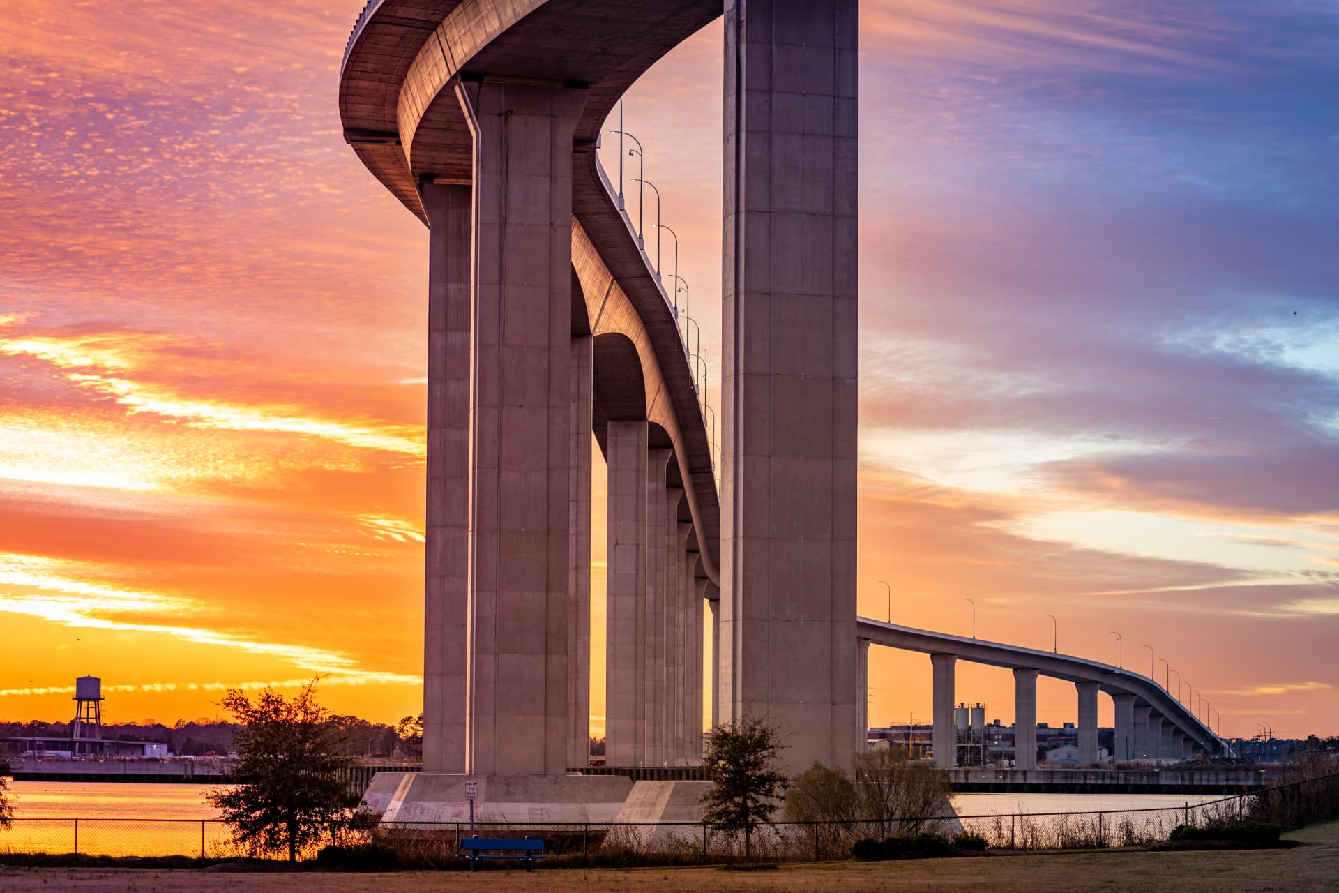 Bridge spanning a river beside a revitalized waterfront park